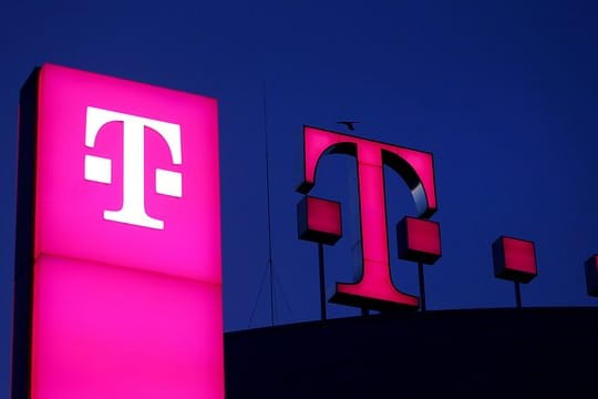 Das Logo der Deutschen Telekom leuchtet auf dem Dach der Unternehmenszentrale.