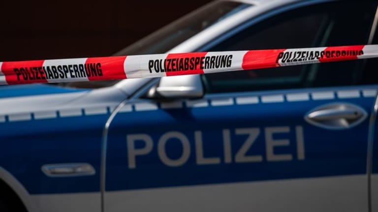 Ein Polizeiauto steht hinter einem Absperrband (Symbolbild): Polizisten haben bei zwei Drogendealern Drogen im Wert von 150.000 Euro gefunden.