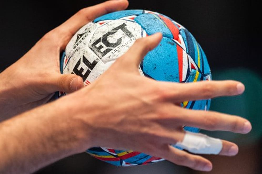 Ein Handball in Händen eines Spielers.