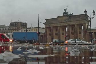 Berlin: Regentropfen sorgen für große Blasen auf einer Pfütze am Brandenburger Tor.