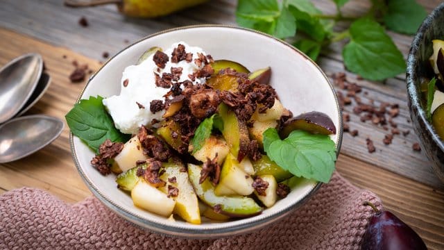 Wenn Birne und Pflaume sich zusammen tun: Für den nötigen Biss in diesem Salat sorgt das Schoko-Nuss-Crunch als Topping.