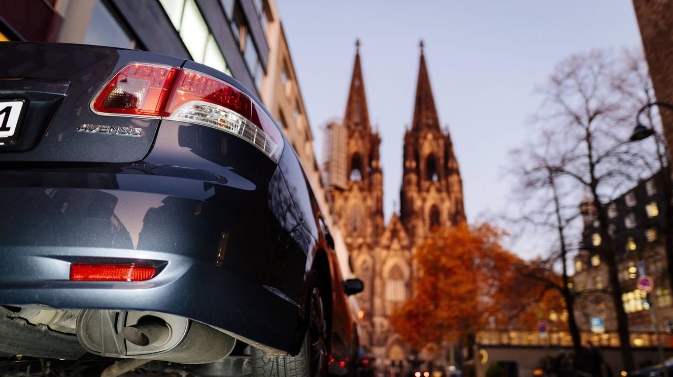 Ein Auto ist vor dem Hintergrund des Kölner Doms (Symbolbild): Sie haben in der Ehrenstraße eigentlich keinen Zutritt.