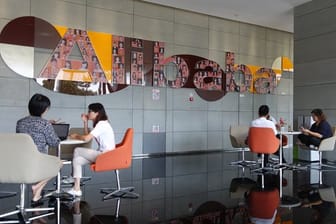 Mitarbeiter sitzen in einem Foyer der Firmenzentrale von Alibaba in Hangzhou.