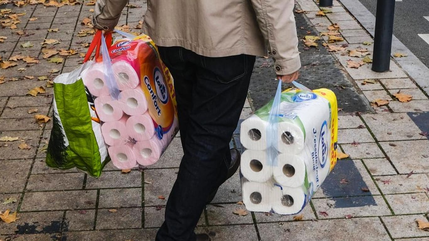 Ein Mann kauft Toilettenpapier (Symbolbild): Das Produkt war vor dem Teil-Lockdown wieder sehr beliebt.