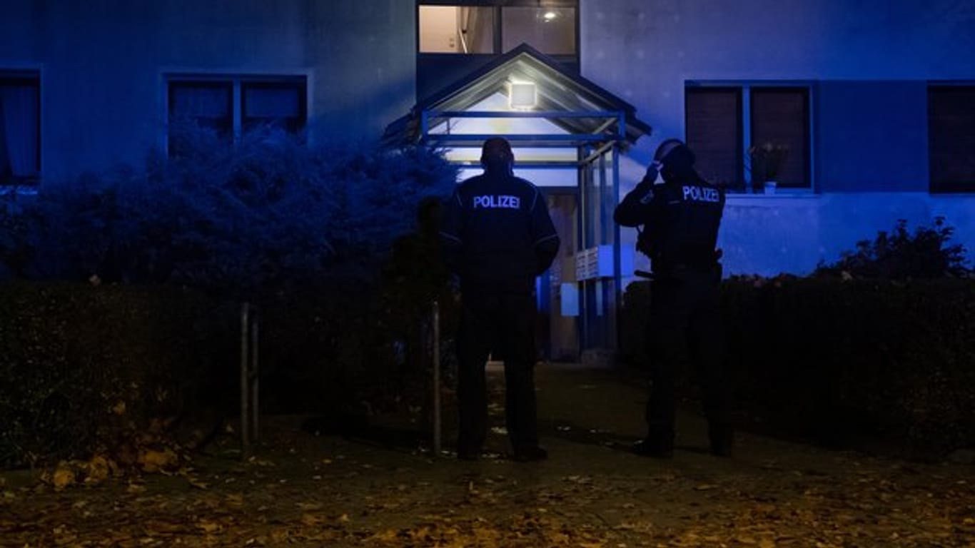 Polizeibeamte vor einem Mehrfamilienhaus im Berliner Ortsteil Plänterwald.