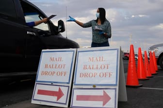 Stimmabgabe: Ein Wahlhelfer nimmt einen Wahlschein in einem Drive-Thru-Wahllokal für Briefwahl entgegen. Mehr Amerikaner als sonst haben von der Briefwahl Gebrauch gemacht. In der Datenbank finden sich aber auch Stimmabgaben mit den Daten längst Verstorbener.