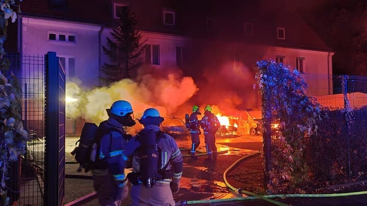 Feuerwehrkräfte stehen vor brennenden Autos: In Berlin-Tegel hat es auf einem Gelände der Bundespolizei gebrannt. Feuerwehrkräfte stehen vor brennenden Autos: In Berlin-Tegel hat es auf einem Gelände der Bundespolizei gebrannt.
