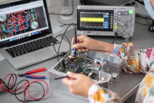 Eine Frau zeigt in einem Labor des Technologieunternehmens Qant eine Spannungsmessung an einem Quantensensor (gestellte Szene).