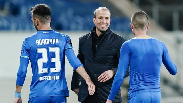 Hoffenheims Trainer Sebastian Hoeneß (M) freut sich nach Spielende mit Sargis Adamyan (l) und Mijat Gacinovic über den Sieg. Hoffenheims Trainer Sebastian Hoeneß (M) freut sich nach Spielende mit Sargis Adamyan (l) und Mijat Gacinovic über den Sieg.