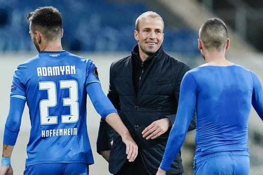 Hoffenheims Trainer Sebastian Hoeneß (M) freut sich nach Spielende mit Sargis Adamyan (l) und Mijat Gacinovic über den Sieg.