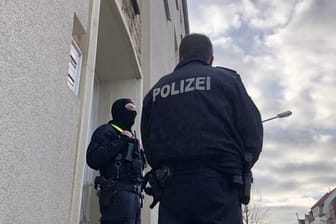 Maskierte Polizisten im Rahmen einer Durchsuchung vor einem Wohnhaus in Osnabrück.