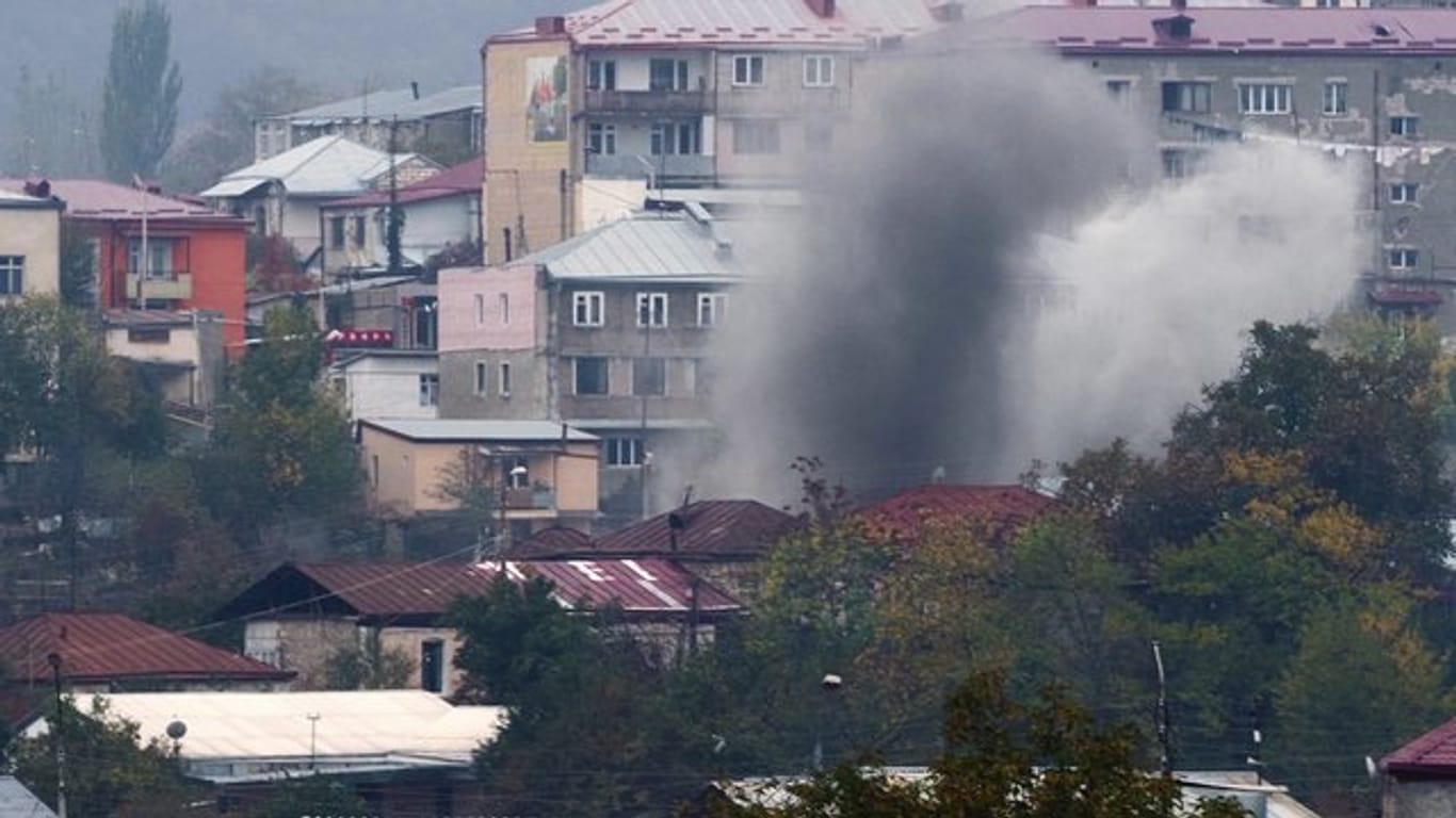 Rauch steigt nach dem Beschuss durch die aserbaidschanische Artillerie zwischen Gebäuden in Stepanakert auf.