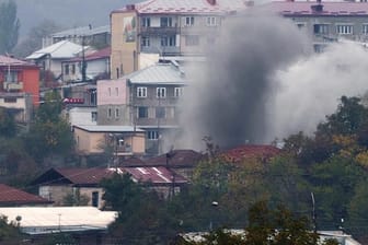 Rauch steigt nach dem Beschuss durch die aserbaidschanische Artillerie zwischen Gebäuden in Stepanakert auf.
