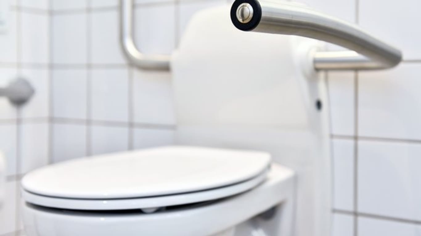 Toilette mit Griffen: Ein Griff kann älteren Menschen helfen, auch auf Toiletten mit normaler oder niedriger Sitzhöhe sicher Platz nehmen zu können.