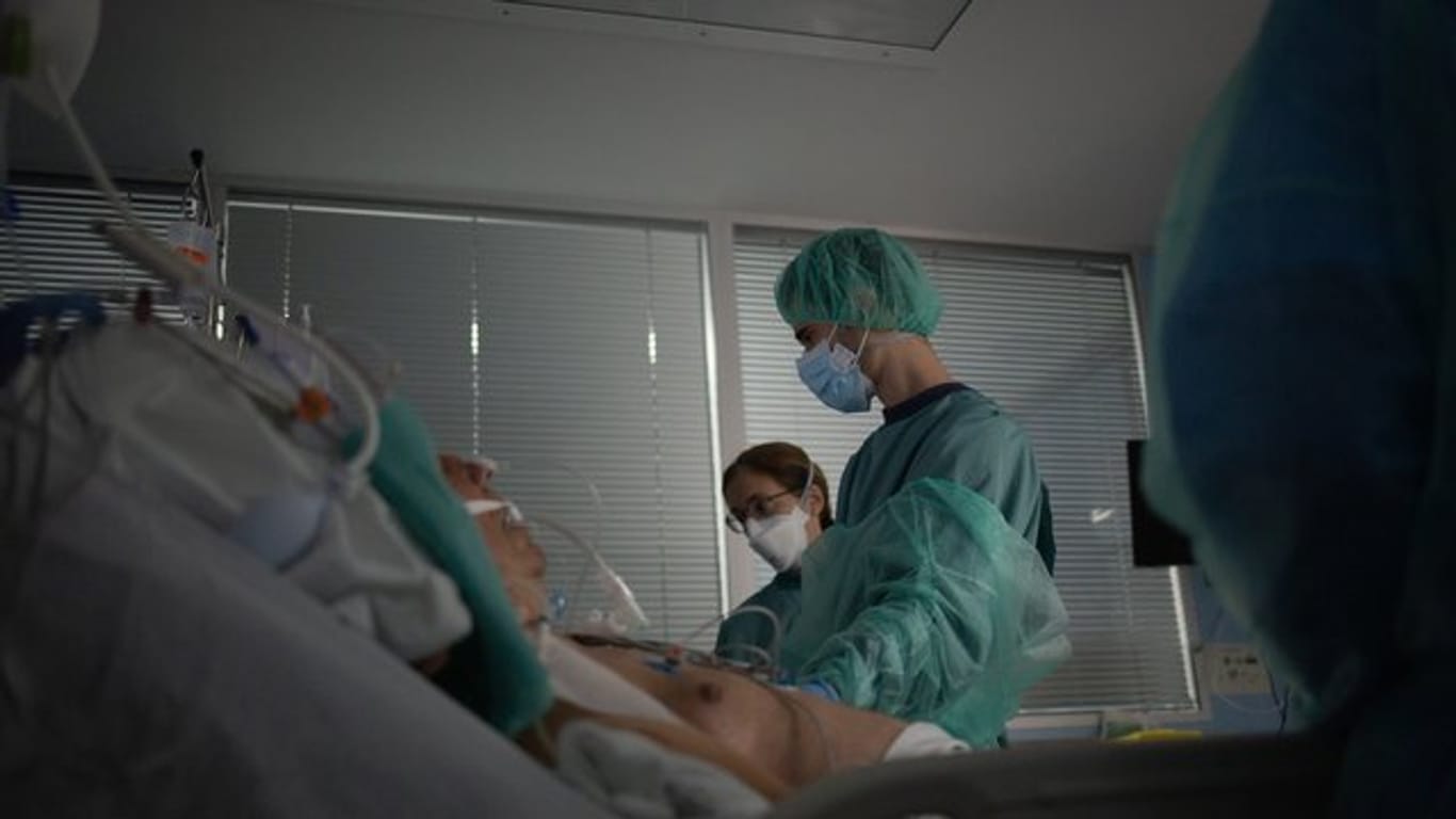 Gesundheitspersonal behandelt auf der Intensivstation eines Krankenhauses in Spanien einen Patienten.