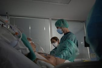 Gesundheitspersonal behandelt auf der Intensivstation eines Krankenhauses in Spanien einen Patienten.