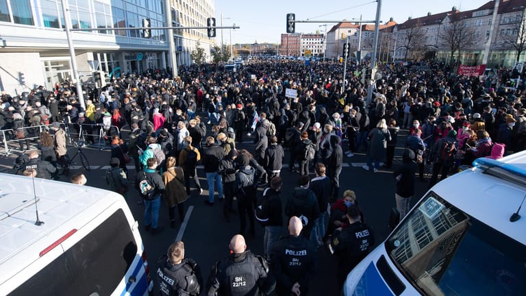 Gegendemonstranten stehen auf dem Augustusplatz: An der Kundgebung gegen die von Bund und Ländern beschlossenen Corona-Maßnahmen nehmen mehrere Tausend Menschen teil.