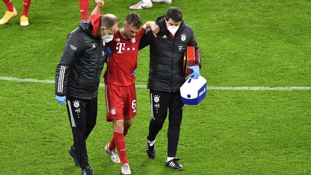 Bayerns Joshua Kimmich geht nach einer ärztlichen Behandlung gestützt von den Betreuern vom Platz. Bayerns Joshua Kimmich geht nach einer ärztlichen Behandlung gestützt von den Betreuern vom Platz.