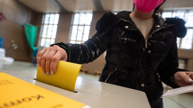 Eine Frau mit Mund- und Nasen-Schutzmaske gibt ihre Stimme ab: Stuttgart wählt einen neuen Oberbürgermeister.