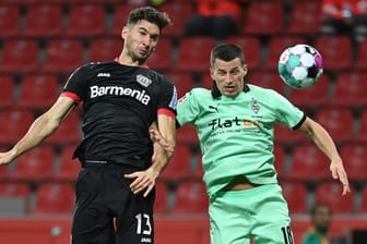 Lucas Alario (l) kämpft mit Mönchengladbachs Verteidiger Stefan Lainer um den Ball.