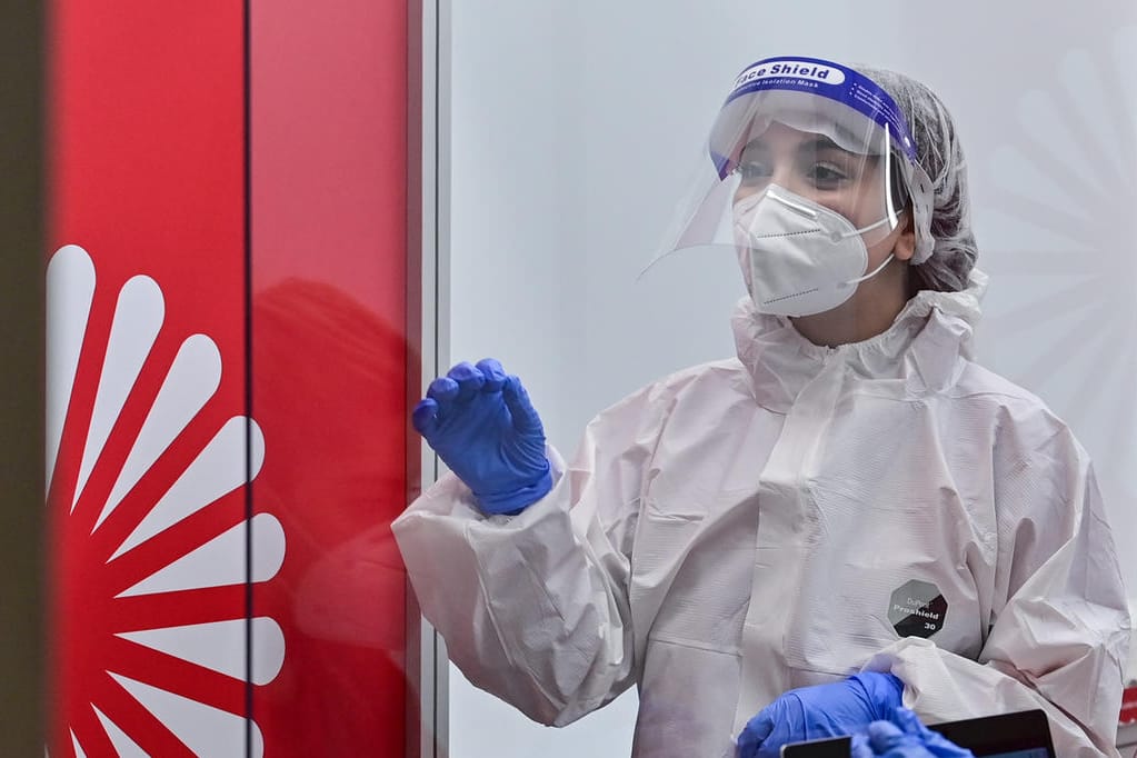 Eine Mitarbeiterin des Corona-Testzentrums am Flughafen BER: Die Zahl der Neuansteckung am Sonntag hat sich nur ein wenig erhöht.