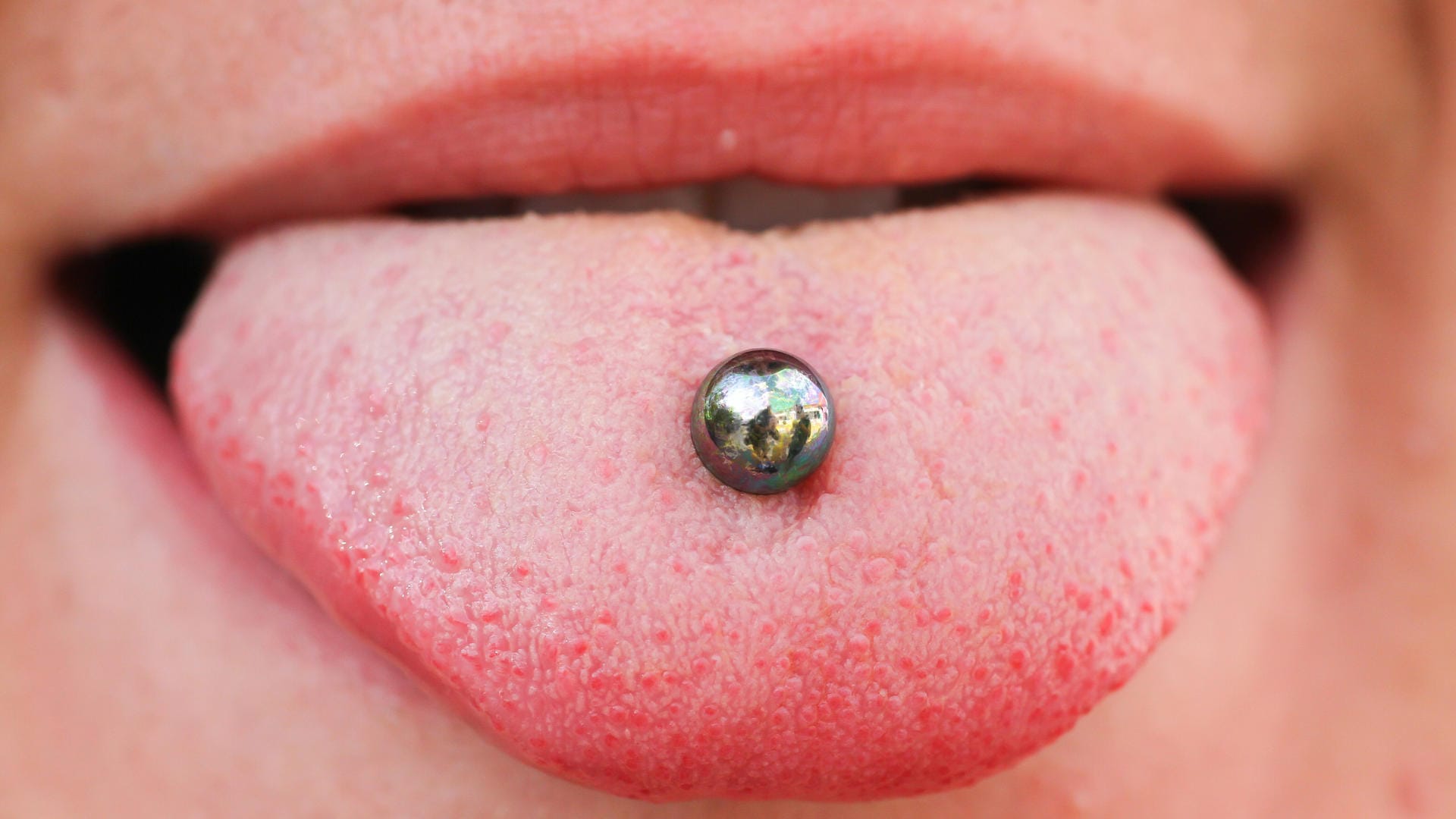 Piercing: Eltern könnten in einem Gespräch mit dem Kind über mögliche Schattenseiten von Piercings und Tattoos reden.