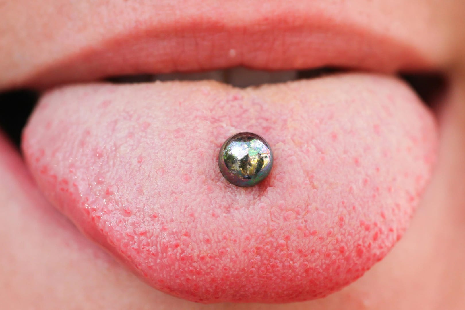 Piercing: Eltern könnten in einem Gespräch mit dem Kind über mögliche Schattenseiten von Piercings und Tattoos reden.