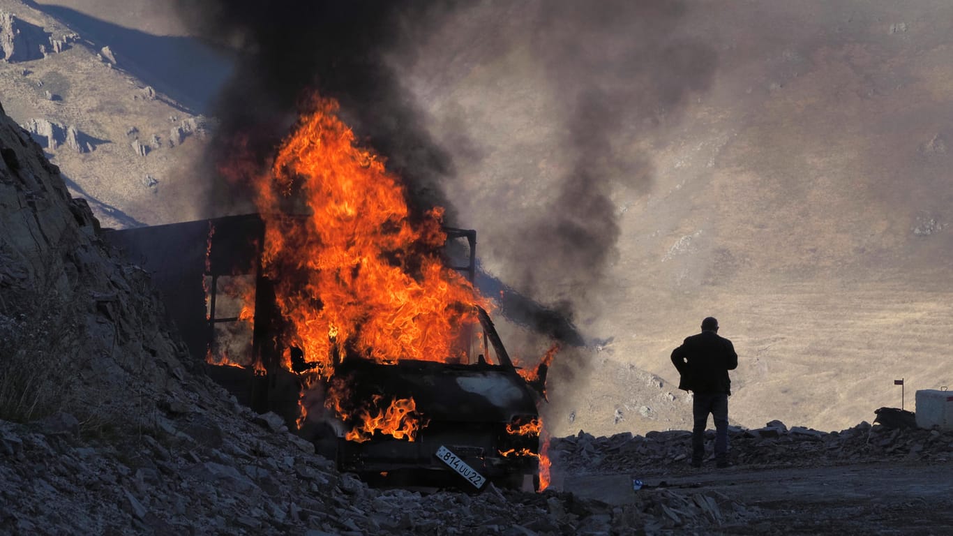 Ein Mann neben einem brennenden Auto in Bergkarabach: Der Krieg um die umkämpfte Region dauert an.