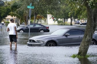 Ein Mann watet nach starken Regenfällen, ausgelöst von Tropensturm "Eta", durch das Hochwasser einer überschwemmten Straße in Fort Lauderdale.