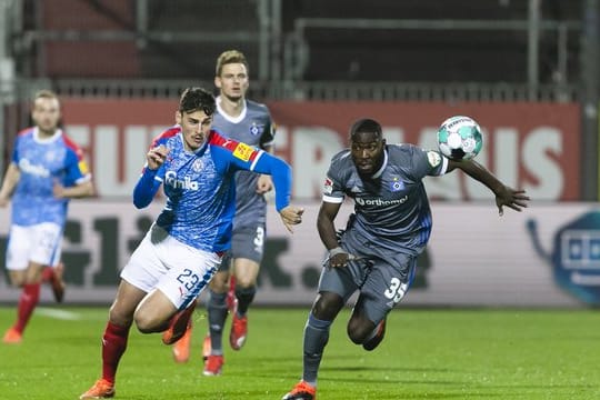 Kiels Janni Serra (l) und Stephan Ambrosius vom HSV kämpfen um den Ball.