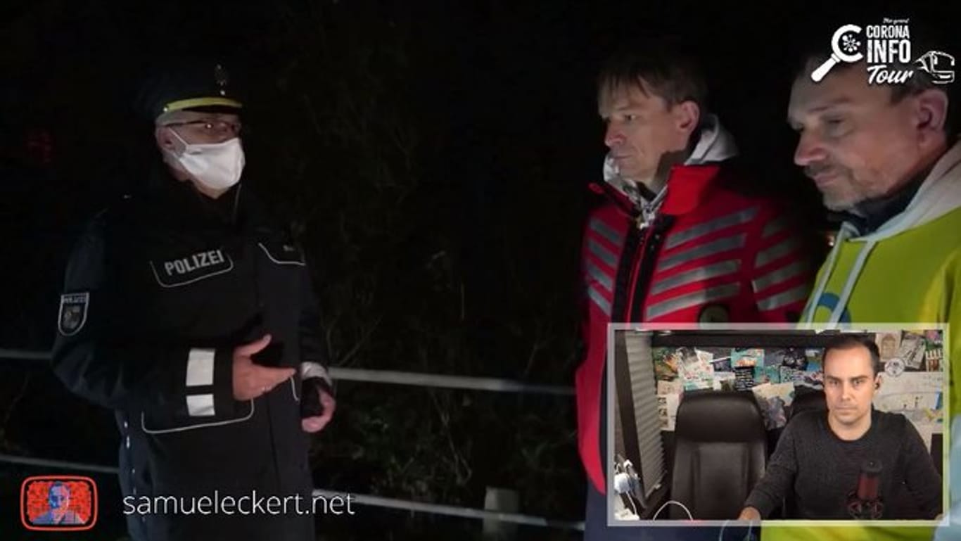 Gestoppt: Bodo Schiffmann (rote Jacke) und "Querdenken"-Anwalt Ralf Ludwig (gelbe Jacke) mit dem örtlichen Polizeichef Torsten Rusch, der ihnen erklärte, dass sie unerlaubt in Mecklenburg-Vorpommern sind.