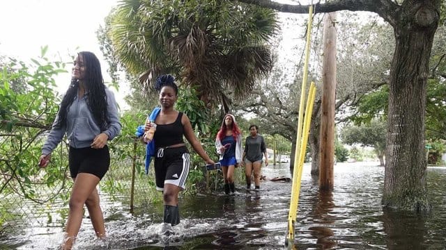 Vier junge Frauen waten durch das Hochwasser nach starken Regenfällen ausgelöst von Tropensturm "Eta" nördlich des Broward Boulevards in Florida. Vier junge Frauen waten durch das Hochwasser nach starken Regenfällen ausgelöst von Tropensturm "Eta" nördlich des Broward Boulevards in Florida.