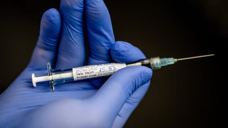 Ein Mann hält eine Spritze mit Impfstoff in der Hand: Die Senatsgesundheitsverwaltung plant bereits die Errichtung von Corona-Impfzentren.