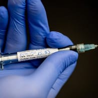 Ein Mann hält eine Spritze mit Impfstoff in der Hand: Die Senatsgesundheitsverwaltung plant bereits die Errichtung von Corona-Impfzentren.