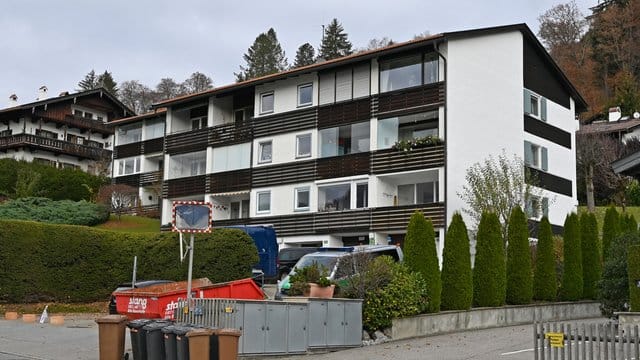 Ein Polizeiauto steht vor einem Tatort. Ein Polizeiauto steht vor einem Tatort.