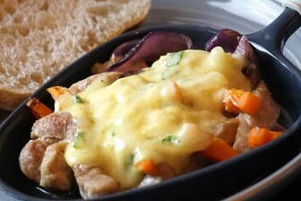 Das marinierte Zwiebelfleisch gart im Raclette-Pfännchen zunächst 5 Minuten, erst dann kommt die Käse-Mascarpone oben drauf und wird nochmals 5 Minuten überbacken.