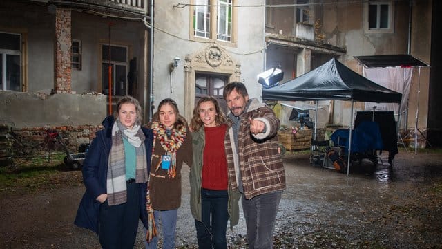 Die Schauspieler Cornelia Gröschel (l-r), Hannah Schiller, Karin Hanczewski und Wanja Mues stehen am Rande der "Tatort"-Dreharbeiten vor dem Schloss Pinnewitz.