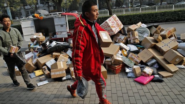 Zusteller sortieren Pakete, die sich an einem Abholpunkt in der Nähe eines Wohnhauses in Peking stapeln. Zusteller sortieren Pakete, die sich an einem Abholpunkt in der Nähe eines Wohnhauses in Peking stapeln.