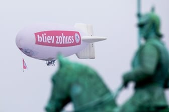 Ein Zeppelin mit der Aufschrift "bliev zohuss" (Bleib zu Hause) der Roten Funken hinter dem Reiterdenkmal in Köln.