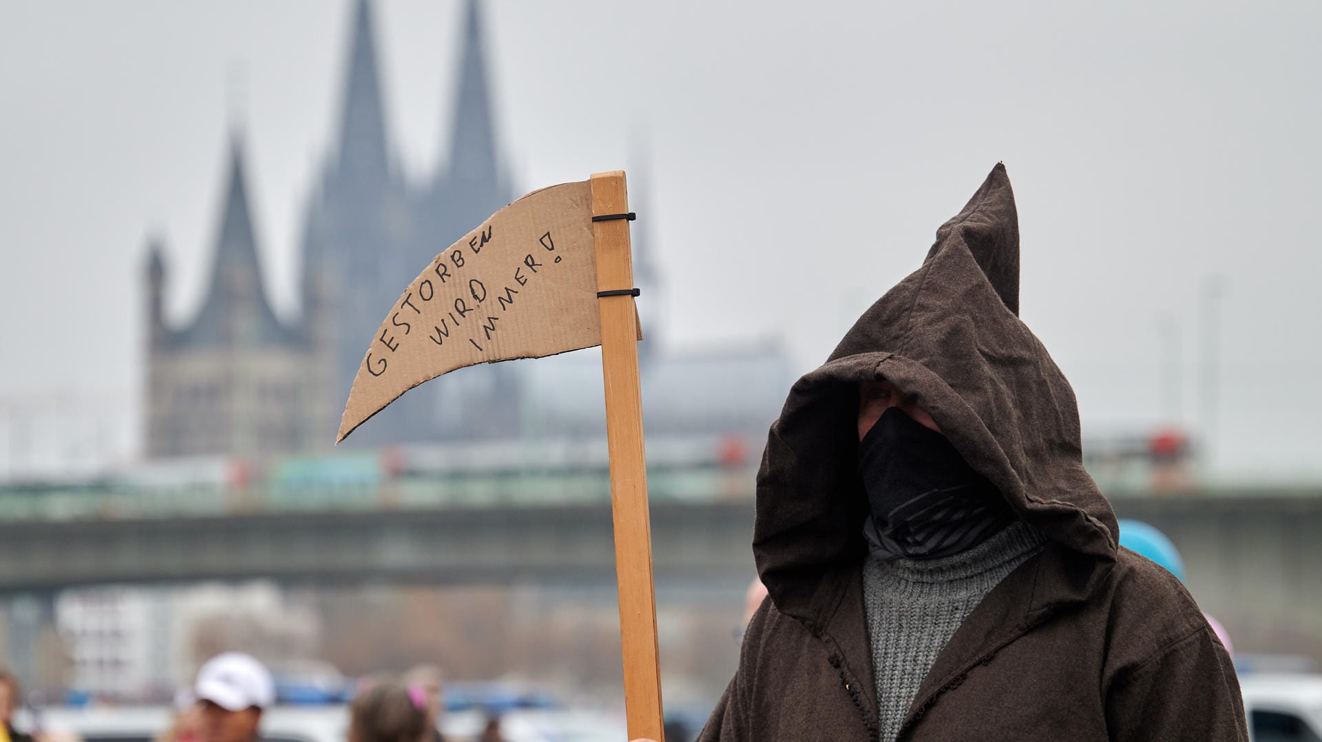 Ein als Sensenmann verkleideter Teilnehmer bei einer Demonstration gegen Corona-Schutzmaßnahmen in Köln: Bei der Veranstaltung kamen etwa 120 Menschen. Ein als Sensenmann verkleideter Teilnehmer bei einer Demonstration gegen Corona-Schutzmaßnahmen in Köln: Bei der Veranstaltung kamen etwa 120 Menschen.