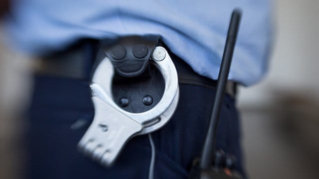 Blick auf die Handschellen eines Justizbeamten im Landgericht (Symbolbild): Ein 22-Jähriger muss in Haft, weil er seinen jungen Sohn zu Tode geschüttelt hat.