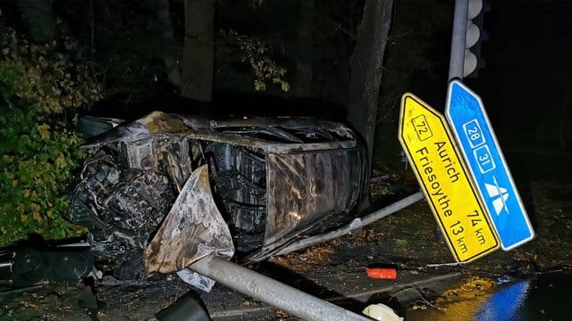 Das ausgebrannte Auto liegt auf der Seite hinter einem umgeknickten Straßenschild und einem auf dem Boden liegenden Ampelmast. Das ausgebrannte Auto liegt auf der Seite hinter einem umgeknickten Straßenschild und einem auf dem Boden liegenden Ampelmast.