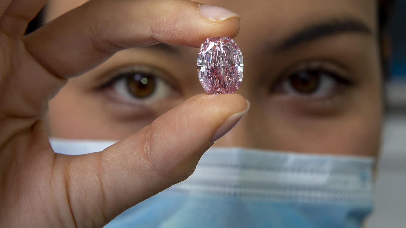 Schweiz, Genf: Eine Mitarbeiterin von Sotheby's hält den Diamanten "The Spirit of the Rose", einen violett-rosa Diamanten mit einem Gewicht von 14,83 Karat.