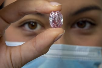 Schweiz, Genf: Eine Mitarbeiterin von Sotheby's hält den Diamanten "The Spirit of the Rose", einen violett-rosa Diamanten mit einem Gewicht von 14,83 Karat.