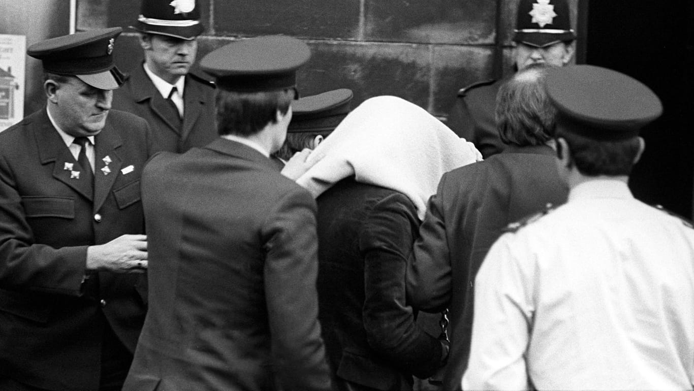 Peter Sutcliffe: Der als "Ripper von Yorkshire" (hier mit Decke auf dem Kopf) bekannt gewordene Serienmörder wird im Jahr 1981 in ein Gerichtsgebäude gebracht. Nun starb er mit dem Coronavirus.