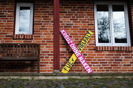 Ein Holzkreuz mit der Aufschrift "Kreuz ohne Haken - fuer Vielfalt" steht an einer Hauswand in Haarstorf im Kreis Uelzen.