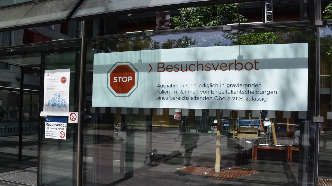 Am Eingang zum Herzzentrum der Kölner Uniklinik erinnert ein Schild an das Besuchsverbot (Archivbild): In Köln müssen immer mehr Corona-Infizierte im Krankenhaus behandelt werden.