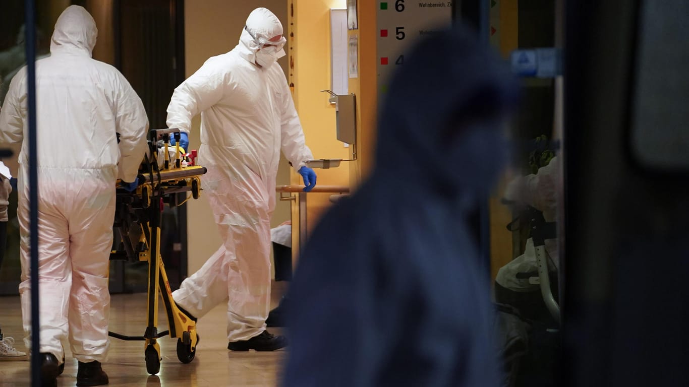 Sanitäter schieben in einem Seniorendomizil im Stadtteil Lichtenberg eine Tragbahre: Die Corona-Infizierten werden in andere Einrichtungen verlegt.