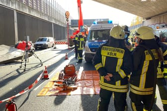 Einsatzkräfte von Polizei und Feuerwehr sichern eine Unfallstelle auf der A3 bei Köln: Eine Betonplatte hatte dort eine Autofahrerin erschlagen, nun beginnt die Ursachensuche.