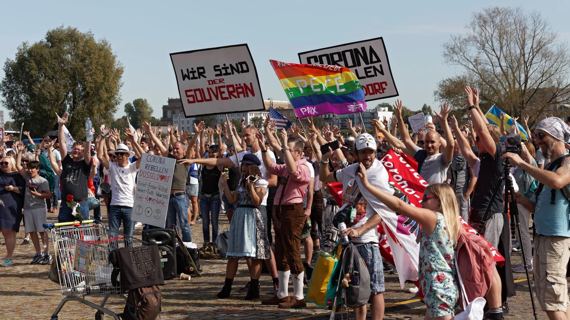 Teilnehmer einer Demo gegen die Corona-Maßnahmen halten im September auf den Rheinwiesen Schilder in die Höhe: Erneut werden Tausende Teilnehmer bei einer Kundgebung erwartet. Teilnehmer einer Demo gegen die Corona-Maßnahmen halten im September auf den Rheinwiesen Schilder in die Höhe: Erneut werden Tausende Teilnehmer bei einer Kundgebung erwartet.